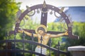 Wooden old christian shrine depicting Jesus on the cross, behind a metallic fence and with spider webs in it, in rural Romania