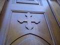 Wooden old church door. Carved wooden cross and varnished, smooth surface, shining in natural light Royalty Free Stock Photo