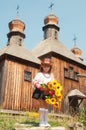 Wooden old church. Little Ukrainian girl. National Museum of Folk Architecture and Life Pirogovo