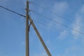 Wooden old 0.4 kV power line support with wires and insulators on blue sky background Royalty Free Stock Photo