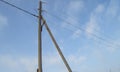 Wooden old 0.4 kV power line support with wires and insulators on blue sky background Royalty Free Stock Photo