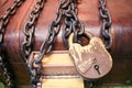 Wooden, old, old brown chest locked to a large lock tied with thick, strong metal chains.