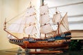 Wooden old sail ship model on a stand on a glass table. Royalty Free Stock Photo