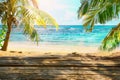 Wooden old table of free space for your decoration. Summer beach landscape with palms and ocean. Summer suny day and sun light.