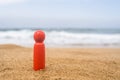 Wooden one, alone figure of red, dark color of man on the sand of beach with sea view. Concept of vacation. individual traveller.