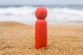 Wooden one, alone figure of red, dark color of man on the sand of beach with sea view. Concept of vacation. individual traveller.