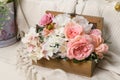 a wooden open box with pink plastic flowers stands on a light background Royalty Free Stock Photo