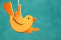 Wooden orange bird on turquoise