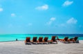 Wooden orange deck chairs on a pier on the background of the azure water, Indian Ocean, Maldives