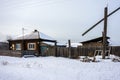 A wooden ordinary house in a small Siberian village in the winter season.