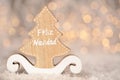 Wooden ornament cutout in the shape of a pine tree - translation text Feliz Navidad - merry christmas