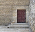 Wooden ornate engraved red door on bricks stone wall and deck stairs Royalty Free Stock Photo