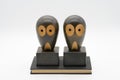 wooden owl bookends on a black book isolated on a white background