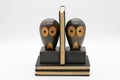 wooden owl bookends with open eyes standing on two black books isolated on a white background Royalty Free Stock Photo