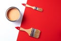 Wooden paint brushes, open paint can on trendy red and white background. Top view, copy space. Appartment renovation Royalty Free Stock Photo