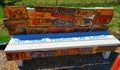 Wooden painted peace bench created by children with translations of peace in different languages