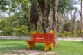 Wooden painted red and yellow bench in garden Royalty Free Stock Photo