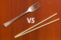 Wooden pairs of chopsticks vs fork. Abstract conceptual image Royalty Free Stock Photo