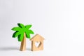 Wooden palm tree and house with hearts on a white background. Conceptual leisure and vacation. Rental homes and properties in the Royalty Free Stock Photo