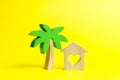 Wooden palm tree and house with hearts on an yellow background. Rental homes and properties in the resort. Romantic travel Royalty Free Stock Photo