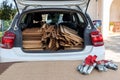 Wooden panels loaded into rear of white car with red workmans gloves in the foregorund