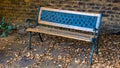 Wooden park bench in dry leaves Royalty Free Stock Photo