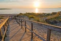 Wooden path at Baltic sea over sand dunes with ocean view, sunset summer evening Royalty Free Stock Photo