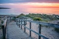 Wooden path at Baltic sea over sand dunes with ocean view, sunset summer evening Royalty Free Stock Photo