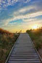 Wooden path at Baltic sea over sand dunes with ocean view, sunset summer evening Royalty Free Stock Photo