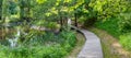 Wooden path in the forest along the river. Royalty Free Stock Photo