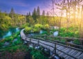 Wooden path in green forest in Plitvice Lakes, Croatia at sunset Royalty Free Stock Photo