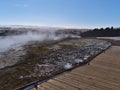 Wooden path leading through geothermal area Geysir, Haukadalur, Iceland, Golden Circle, with hot springs and fumaroles. Royalty Free Stock Photo