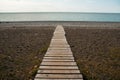 Wooden path on the sandy beach. Beach boardwalk with sand texture background Royalty Free Stock Photo