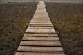 Wooden path on the sandy beach. Beach boardwalk with sand texture background Royalty Free Stock Photo