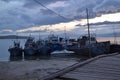 Wooden path to pier jetty with old ships and boats in the evening at sunset with blue clouds on lake baikal, mountains Royalty Free Stock Photo