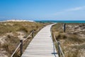 The wooden path to the torquoise water with white sand beach in a sunny day