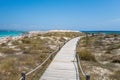 The wooden path to the torquoise water with white sand beach in a sunny day Royalty Free Stock Photo