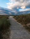 Wooden pathway through dunes to the ocean an cloudy sky in ireland Royalty Free Stock Photo