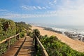 Wooden pathway going to the beach covered with trees by the breathtaking ocean Royalty Free Stock Photo