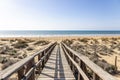 Wooden pathway over dunes and pines at beach in Punta Umbria, Huelva. Los Enebrales beach Royalty Free Stock Photo