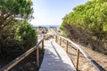 Wooden pathway over dunes and pines at beach in Punta Umbria, Huelva. Los Enebrales beach Royalty Free Stock Photo