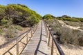 Wooden pathway over dunes and pines at beach in Punta Umbria, Huelva. Los Enebrales beach Royalty Free Stock Photo