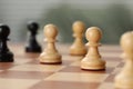 Wooden pawns on chess board, closeup. Space for text