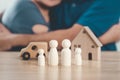 Wooden peg dolls, wooden house, and car with a Hugging man and woman couple. planning, saving family,  health care and insurance, Royalty Free Stock Photo