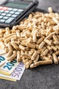Wooden pellets, euro banknotes and calculator. Royalty Free Stock Photo