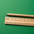 A wooden pencil and ruler are placed on a green textured surface. The pencil is Royalty Free Stock Photo