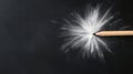 Wooden pencil tip creating white powder explosion on dark textured surface. Royalty Free Stock Photo