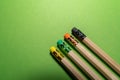 Wooden pencils with colorful erasers on green background Royalty Free Stock Photo