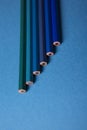 Wooden pencils of different shades of blue on a blue background