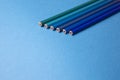 Wooden pencils of different shades of blue on a blue background